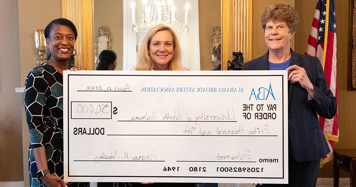 College of Arts, Sciences, and Engineering Dean Dr. Sara Lynn Baird, left; and Dr. Pat Sanders, professor and Chair of the Department of Communication, right, accept the $50,000 Endowed Scholarship Award from Sharon Tinsley, Alabama Broadcasters Association President.